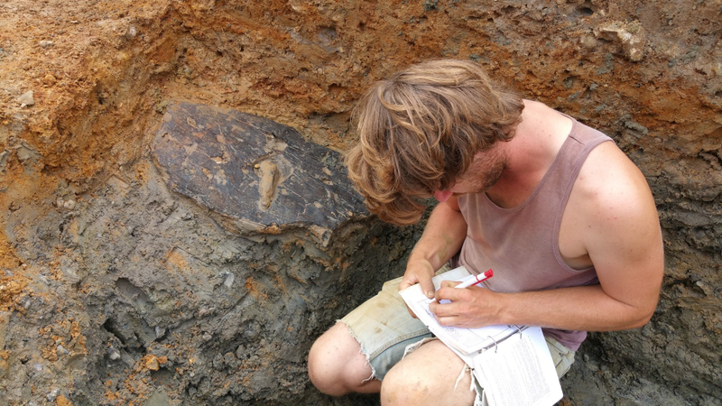 ULAS archaeologist Adam Clapton recording the shield when it was still in the ground.